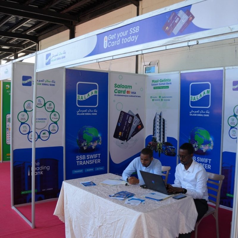Exhibition booth setup with branded panels at a trade show event, featuring Salam Somali Bank and EgyptAir displays, conference seating area, and event infrastructure by a professional event management company